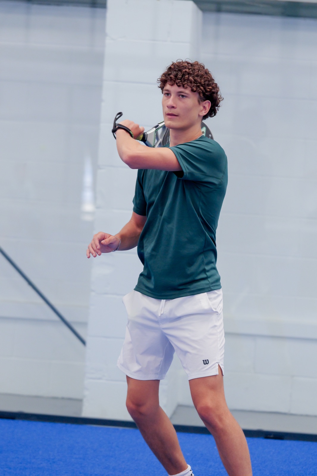 A player following through on a backhand at Padel Quarter
